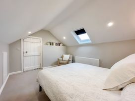 A bedroom with a bed and chair at Victorian Beach House