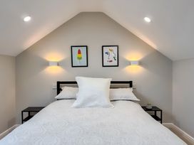 A bedroom with a bed and wall art at Victorian Beach House
