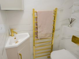 A bathroom with a sink, towel rack, and toilet at Victorian Beach House