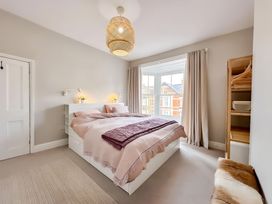 A bedroom with a bed and shelving unit at Victorian Beach House