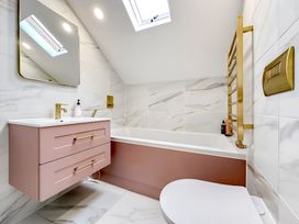 A bathroom with a bathtub, sink, and toilet at Victorian Beach House