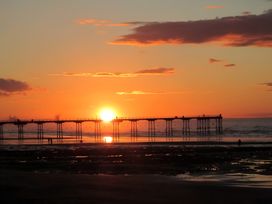 A sunset view over a pier at Victorian Beach House in 