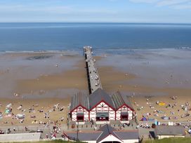 A beach with a pier and people at Victorian Beach House 