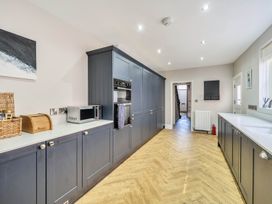 A kitchen with storage units and appliances at Victorian Beach House in Saltburn-By-The-Sea