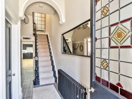 A hallway with stairs and a mirror at Victorian Beach House, Saltburn-By-The-Sea