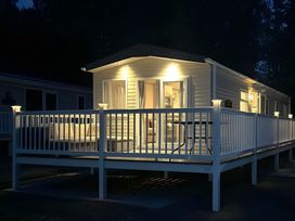 A mobile home exterior with a deck and furniture at Pine 48