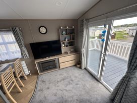 A living room with a TV and a view of the outside at Pine 48