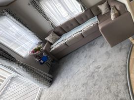 A living room with a sofa and flower arrangement at Pine 48