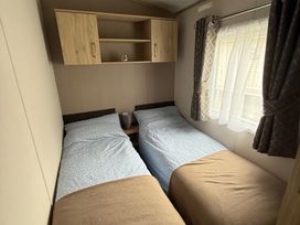 A bedroom with two single beds and a shelf at Pine 48