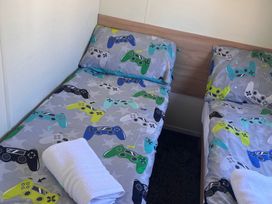 A bedroom with two beds and gaming themed bedding at 214 Oaklands Area