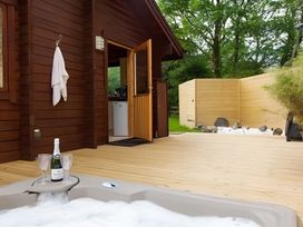 An outdoor area with a hot tub and champagne at Gisburn Forest Lodge