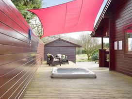 An outdoor space with a hot tub and chairs at Gisburn Forest Lodge