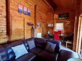 A living room with a sofa and dining area at Gisburn Forest Lodge