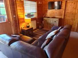 A living room with a sofa and lamp at Gisburn Forest Lodge