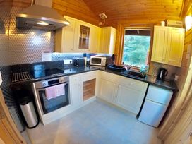 A kitchen with appliances and cabinets at Gisburn Forest Lodge