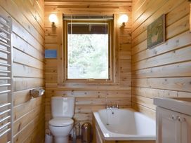 A bathroom with a toilet and bathtub at Gisburn Forest Lodge
