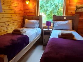 A bedroom with two beds and a window at Gisburn Forest Lodge