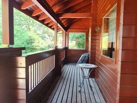 A balcony with a table and chair at Gisburn Forest Lodge