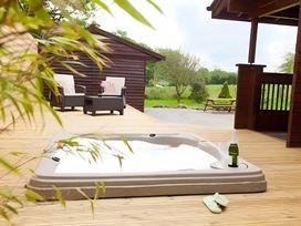 A hot tub with outdoor seating at Gisburn Forest Lodge
