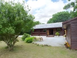 A house with a bench and trees at Gisburn Forest Lodge