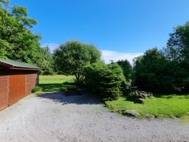 A garden with a shed and picnic table at Gisburn Forest Lodge