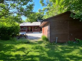 An outdoor area with a cabin and shed at Gisburn Forest Lodge