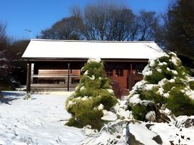 An outdoor view of a house covered in snow at Gisburn Forest Lodge