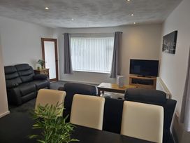 A living room with a sofa and television at 58 Clifton Rise