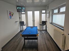 A game room with a pool table and bar stools at 58 Clifton Rise