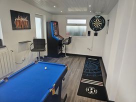 A snug room with a pool table and gaming machine at 58 Clifton Rise