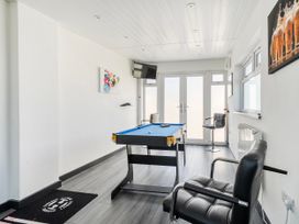 A snug with a pool table and television at 58 Clifton Rise, Abergele