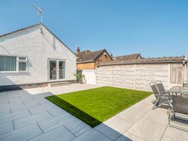 A garden with a patio and grass at 58 Clifton Rise in Abergele