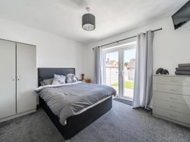 A bedroom with a bed and wardrobe at 58 Clifton Rise in Abergele