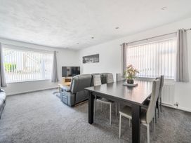 A living room with a dining table and sofa at 58 Clifton Rise Abergele