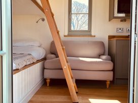 A bedroom with a bed and sofa at Y Nyth