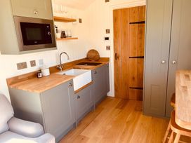A kitchen with cabinets and a sink at Y Nyth in 