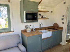 A kitchen with a microwave, sink, and kettle at Y Nyth 