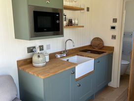 A kitchen with appliances and sink at Y Nyth