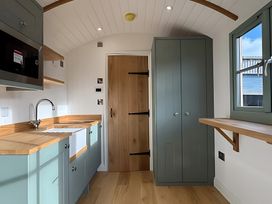 A kitchen with a sink, microwave, and cabinet at Y Nyth