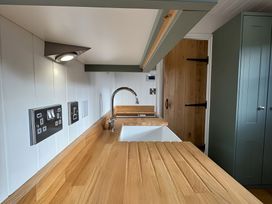 A kitchen with a sink and wood countertop at Y Nyth 