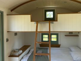 A bedroom with a bed and ladder at Y Nyth