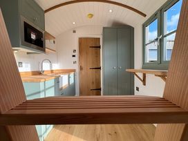 A kitchen with cabinets and a door at Y Nyth