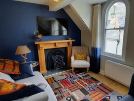 A living room with a sofa and a fireplace at Lil Nauti