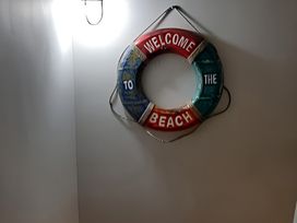 A life ring with the text 'WELCOME TO THE BEACH' on a wall at Lil Nauti