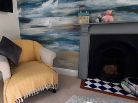 A living room with an armchair and decorative items at Lil Nauti 