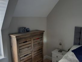 A bedroom with a wooden dresser and bedside table at Lil Nauti