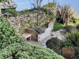 A garden with a stone wall and garden bed at Lil Nauti