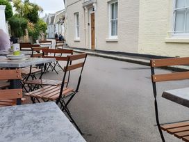 Outdoor seating with tables and chairs in a street at Lil Nauti 