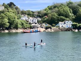 Paddle boarders on water with houses and trees in the background at Lil Nauti