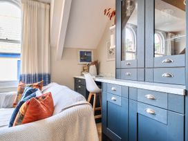 A sitting room with a desk and sofa at Lil Nauti Fowey
